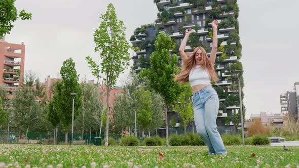 Slow motion young caucasian woman outdoor feeling free and having fun dancing with energy