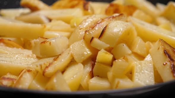 Cooking Fried Potato on Frying Pan. Roasting Sliced Potatoes