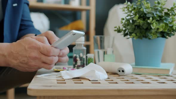 Close-up of Man's Hands Using Smartphone During Coronavirus Pandemic at Home alt