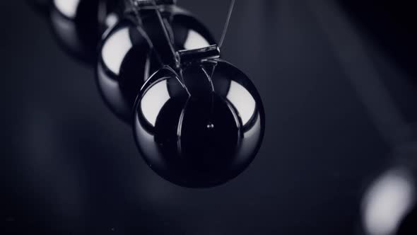 The balls of a Newtons Cradle colliding in slow motion alt