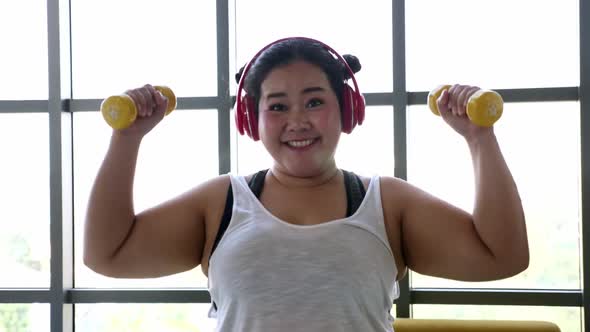 Overweight young woman in sportswear exercising to lose weight at home