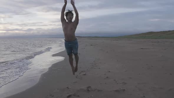 Dancer spin jump on beach