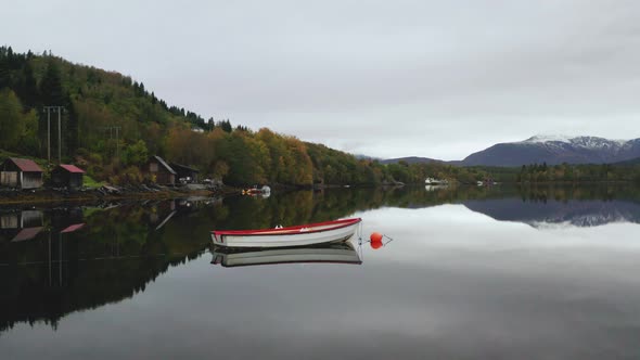 Small Boat Moored On Beautiful Fjord In Norway - aerial drone shot
