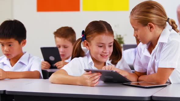 Students using digital tablet in classroom