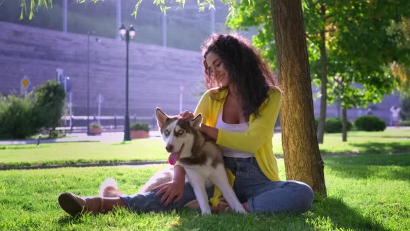 Girl Hugging Dog During Their Outdoor Rest in the Park