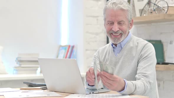 Old Man Counting Dollars at Work