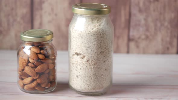 Almond Powder and Almond in a Jar on Table