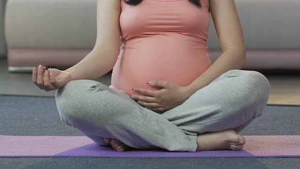 Pregnant Woman Practicing Yoga on Floor, Prenatal Exercising, Physical Activity