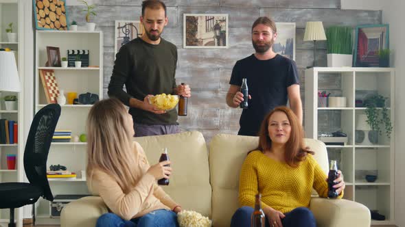 Young Man Offers Girl Chips While Watching a Match on Tv