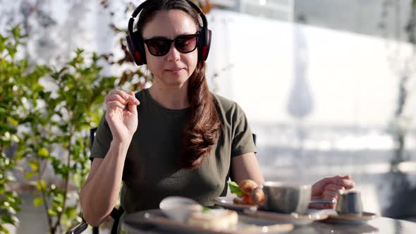 Attractive Adult Woman with Glasses Listening to Music with Headphones Use Smartphone During