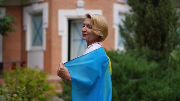 Woman with Ukrainian Flag Turning in Slow Motion Looking at Camera Smiling Standing in Backyard