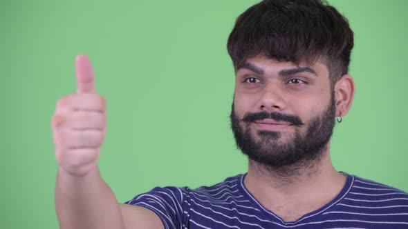 Face of Happy Young Overweight Bearded Indian Man Giving Thumbs Up