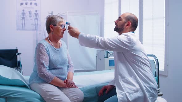 Doctor Measuring Temperature to Senior Woman