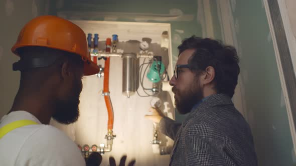 Professional Worker Explaining Owner Work of Independent Heating System in Boiler Room