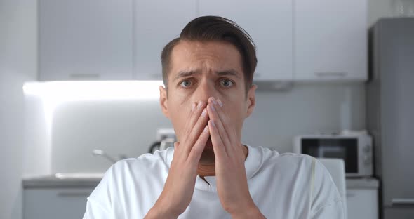 Portrait of Shocked and Surprised Man Sits on Sofa at Home