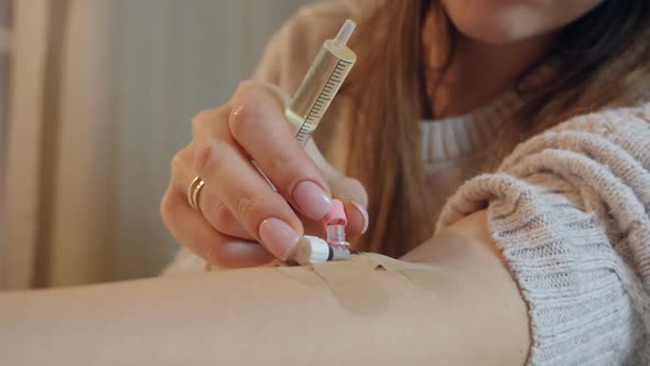 Young Woman Alone at Home Injects Medicine From a Syringe Into a Vein