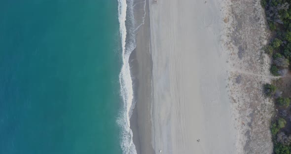 Aerial view waves breaking on the sandy beach