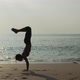 Woman performing sequence of yoga poses by the ocean - VideoHive Item for Sale