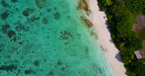 Tropical fly over clean view of a white sand paradise beach and blue water background in hi res 4K