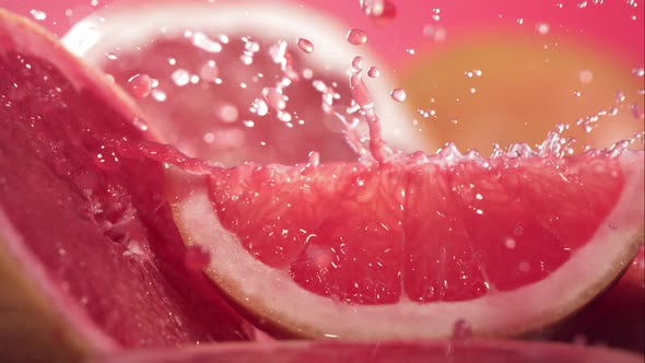 Slow Motion Shot of Grapefruit Juice Splashing Through Grapefruit Slices