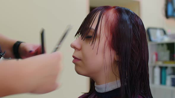 Closeup of a Hairdresser with a Haircut Bangs to a Client