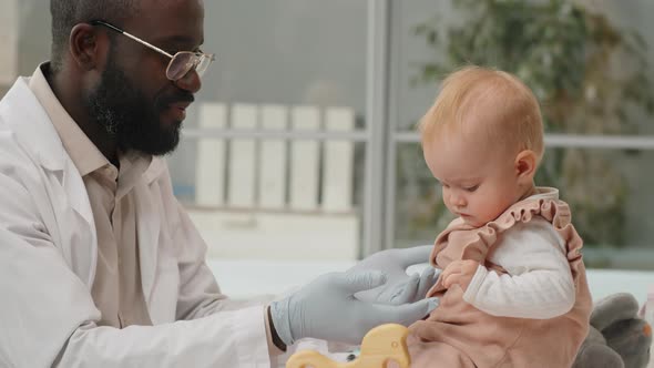 Caucasian Baby on Health Checkup with African American Pediatrician