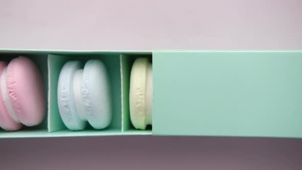 Macaroon in a Paper Box on Light Green Background