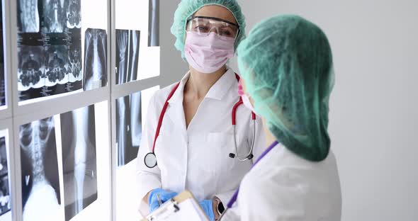 Doctors Wearing Goggles and Protective Face Masks Looking at Xrays in Clinic  Movie