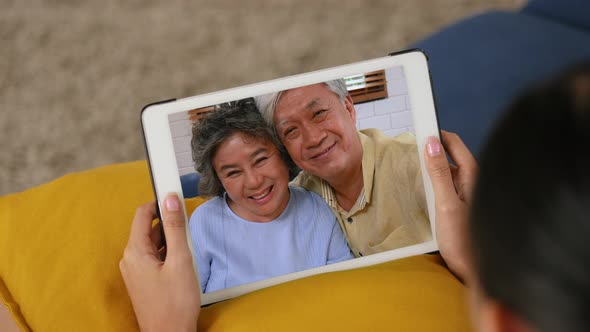 Young Asian grandchild having video chat with Grandfather and grandmother.