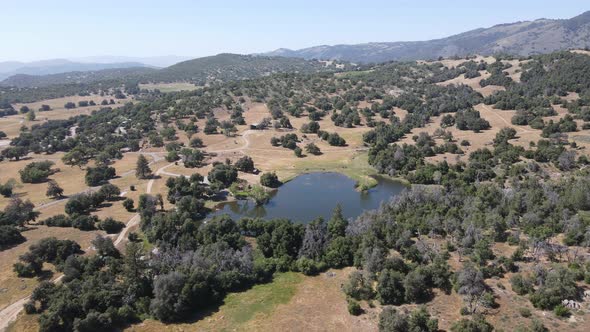 Aerial View of Small Lake in the Valley Between Farmland and Forest in the Town of Julian East of