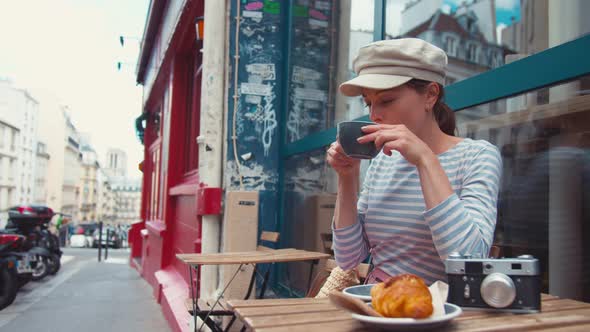 Attractive girl having breakfast in a cafe in Paris