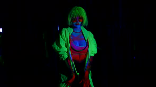 Sexy Lady is Wearing Glowing in Darkness Clothes and Wig is Moving Slowly in Dark Room