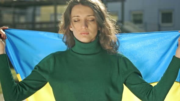 Portrait of a Woman with a Ukrainian Flag on His Shoulders