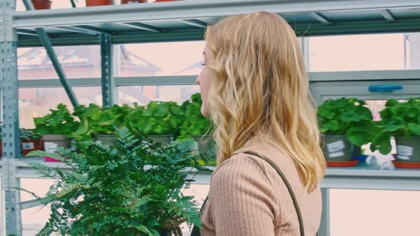 A Florist Walks Past a Shelf with a Wide Variety of Exotic Flowers