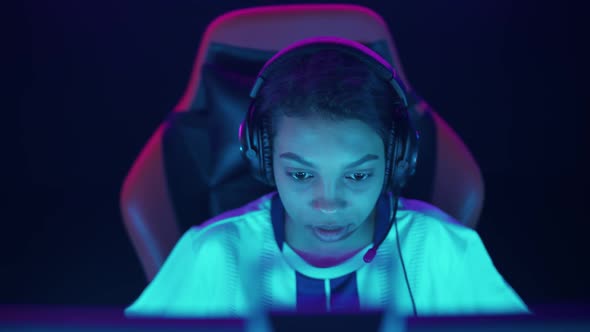 Portrait of a Focused Female Gamer in Headphones Plays a Video Game Cyber Sportsman at the
