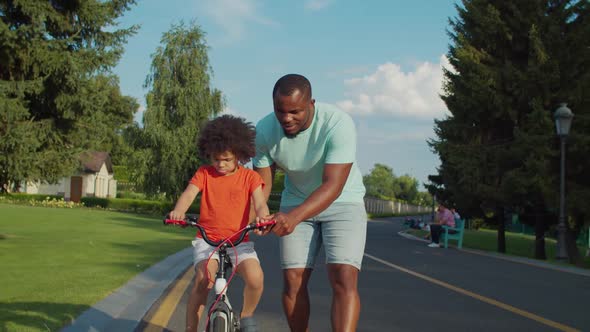 Caring Dad Securing Little Boy at Balance Bike