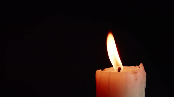 The showcases of colorful single candlelight on black background with the effect of light and slow m