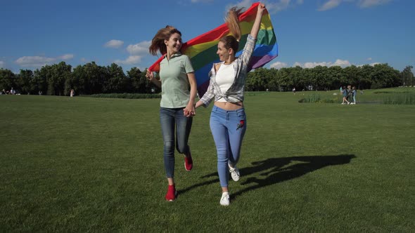 Happy Lesbians with Rainbow Flag Running in Park