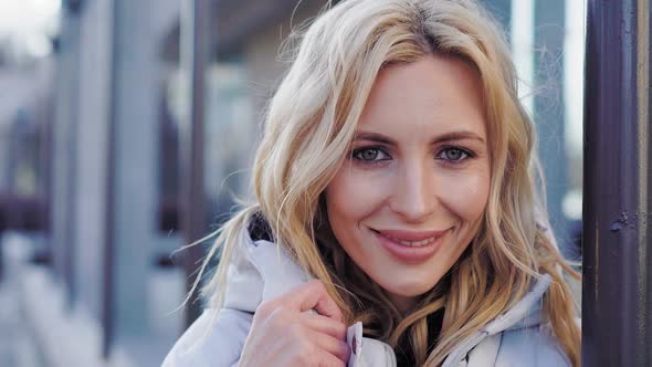 Young Charming Woman in Coat Near Building