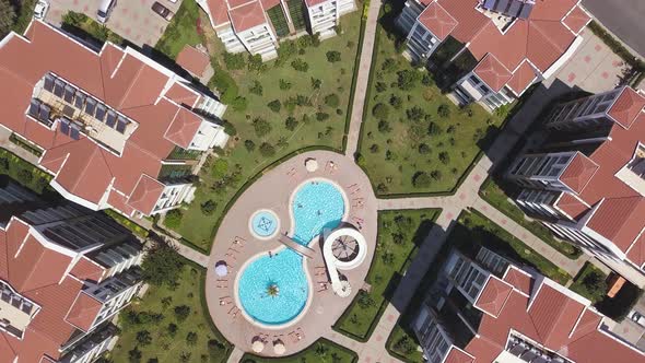 Top aerial view of a swimming pool located outdoors near several residential houses