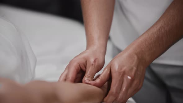 Young Woman Receiving a Massage  Massaging Her Hand with an Oil