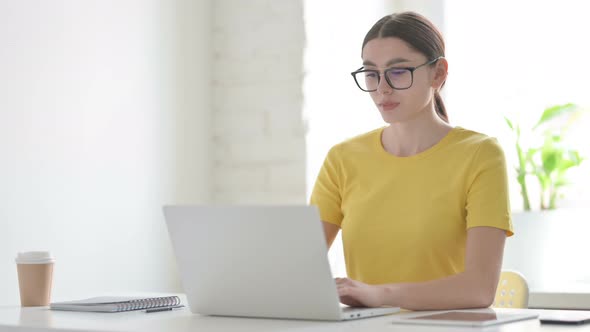 Woman having Neck Pain while using Laptop in Office