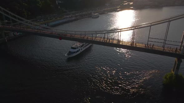 Water Transport Massive Ship is Sailing Under a Big Foot Bridge in Kyiv