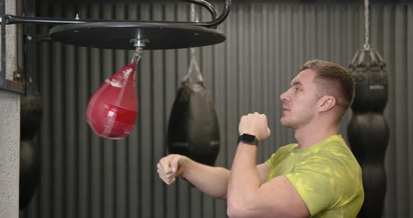Young Athlete in a Bright Yellow Tshirt Boxing a Red Pear