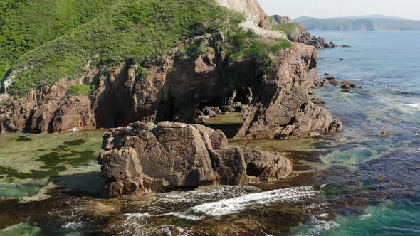 Drone View of a Natural Stone Arch on the Seashore on a Sunny Day