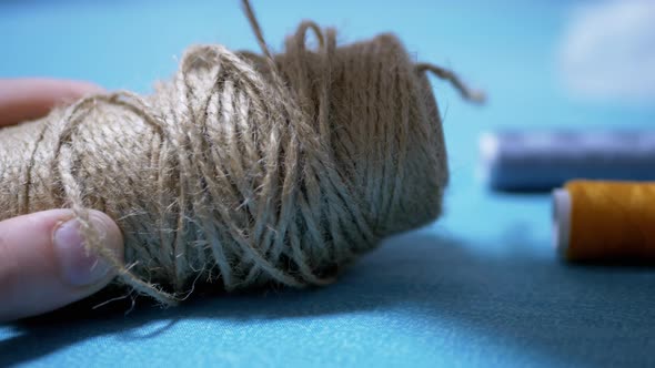 Male Hands Reel Up Jute Twine Rope on Reel