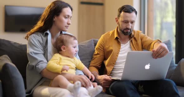 Man Works From Home with His Wife and Little Son