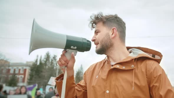 Man at Political Rally with Megaphone Shouts. Activist Screaming at Loudspeaker