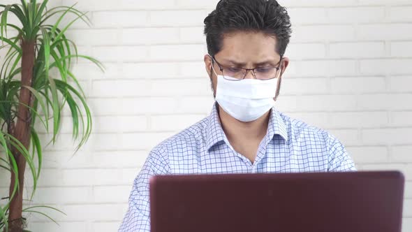 Businessman in Face Mask Working on Laptop