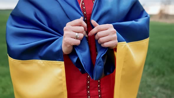 Ukrainian Woman Wrapped in National Flag in Green Field